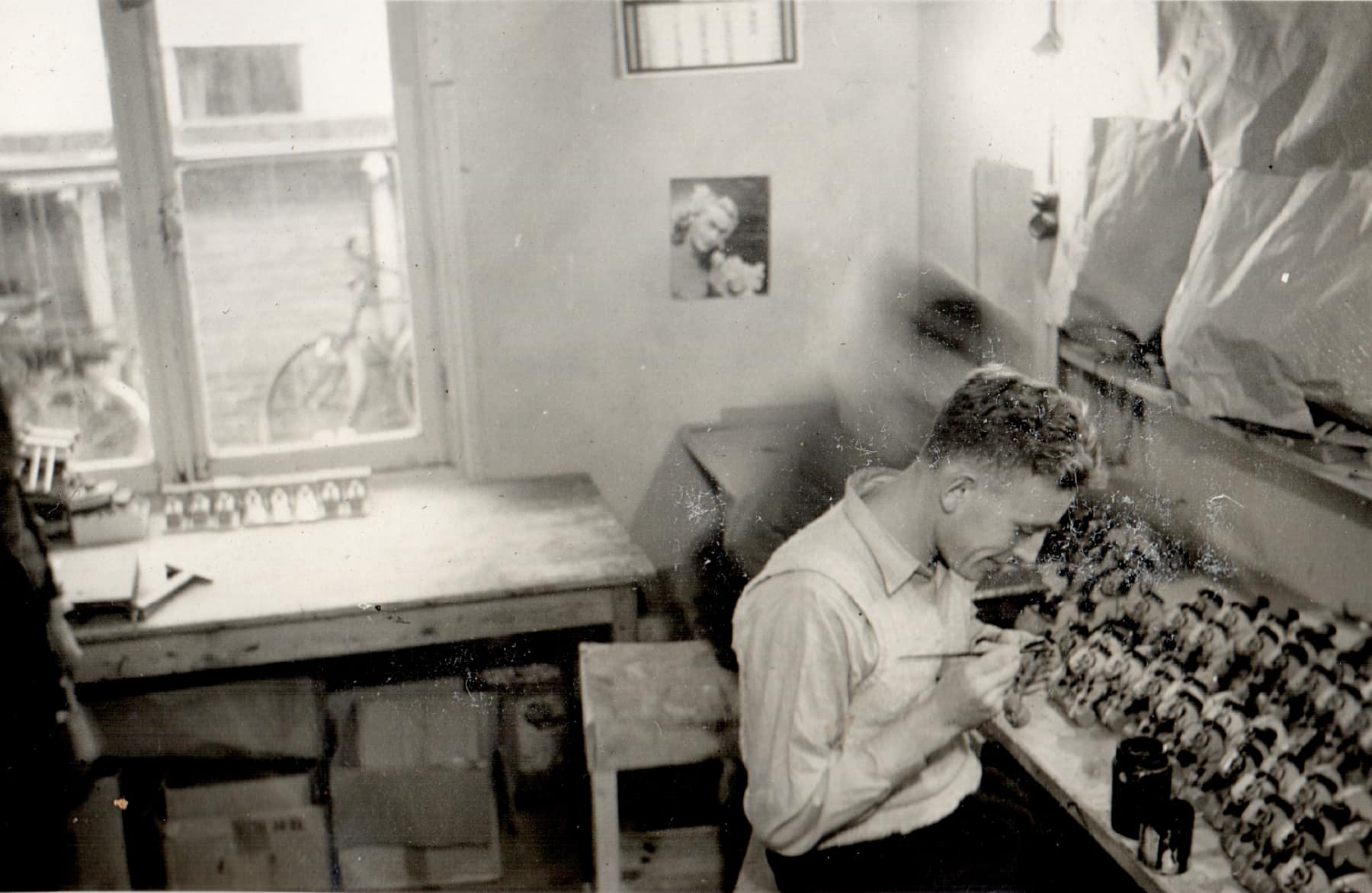 Twee mannen schilderen details op speelgoed roldieren in de KODA fabriek